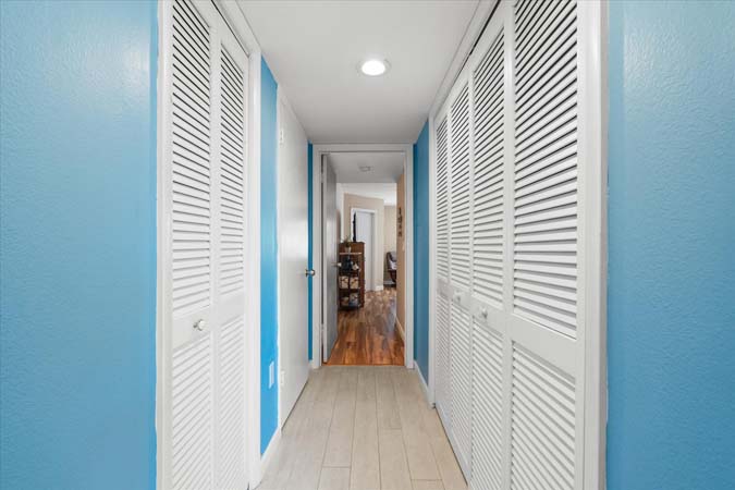 coastal themed living room with smart TV and sliding doors to the waterfront balcony